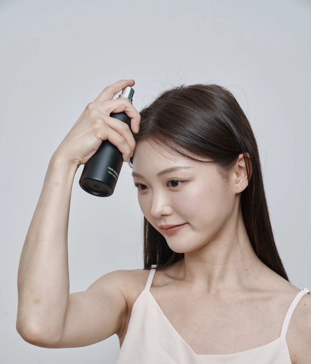 갱년기탈모 원인 두피에 토닉을 가볍게 뿌려 바르는 모습