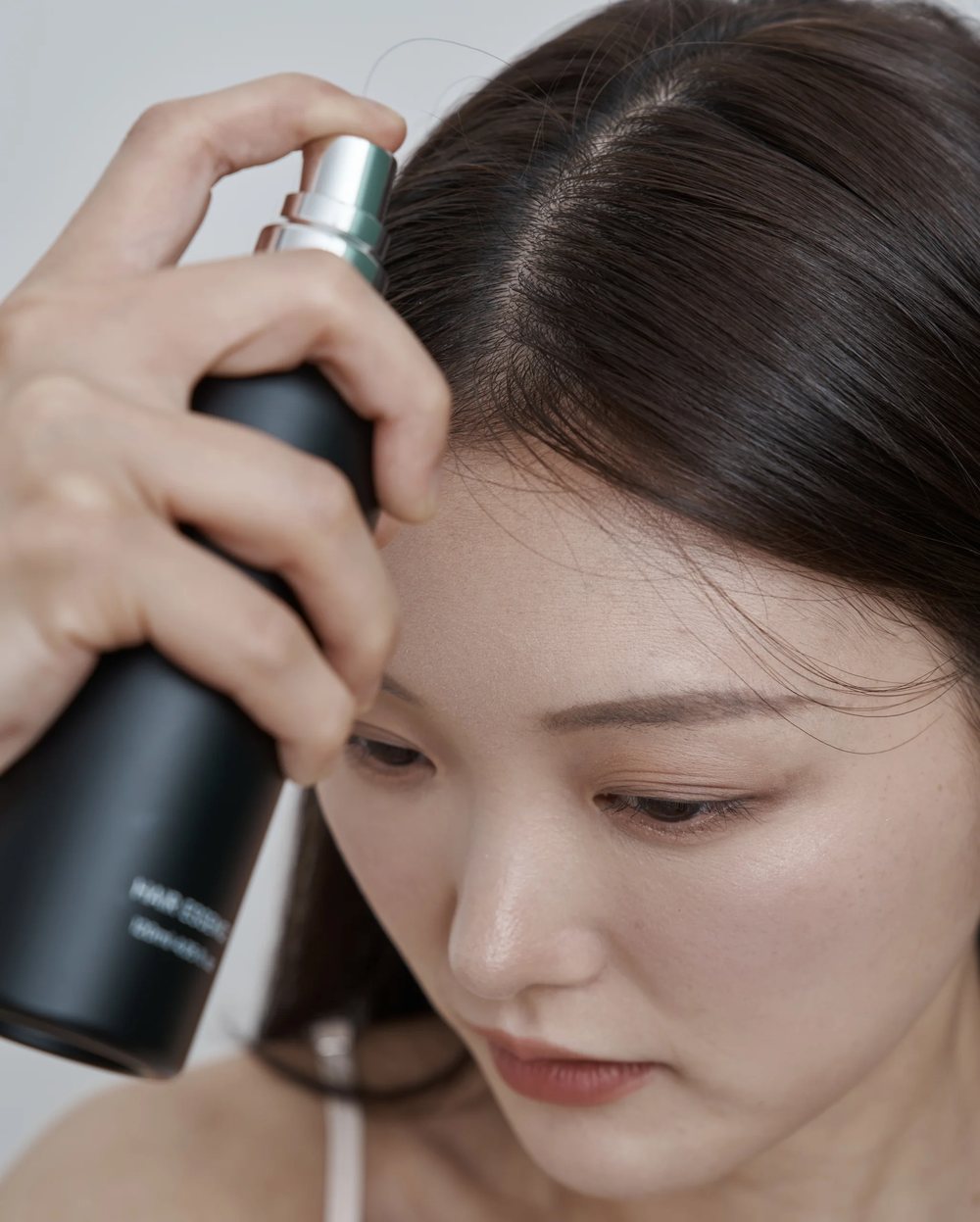 여성 갱년기탈모 가르마 두피에 토닉을 뿌리는 모습